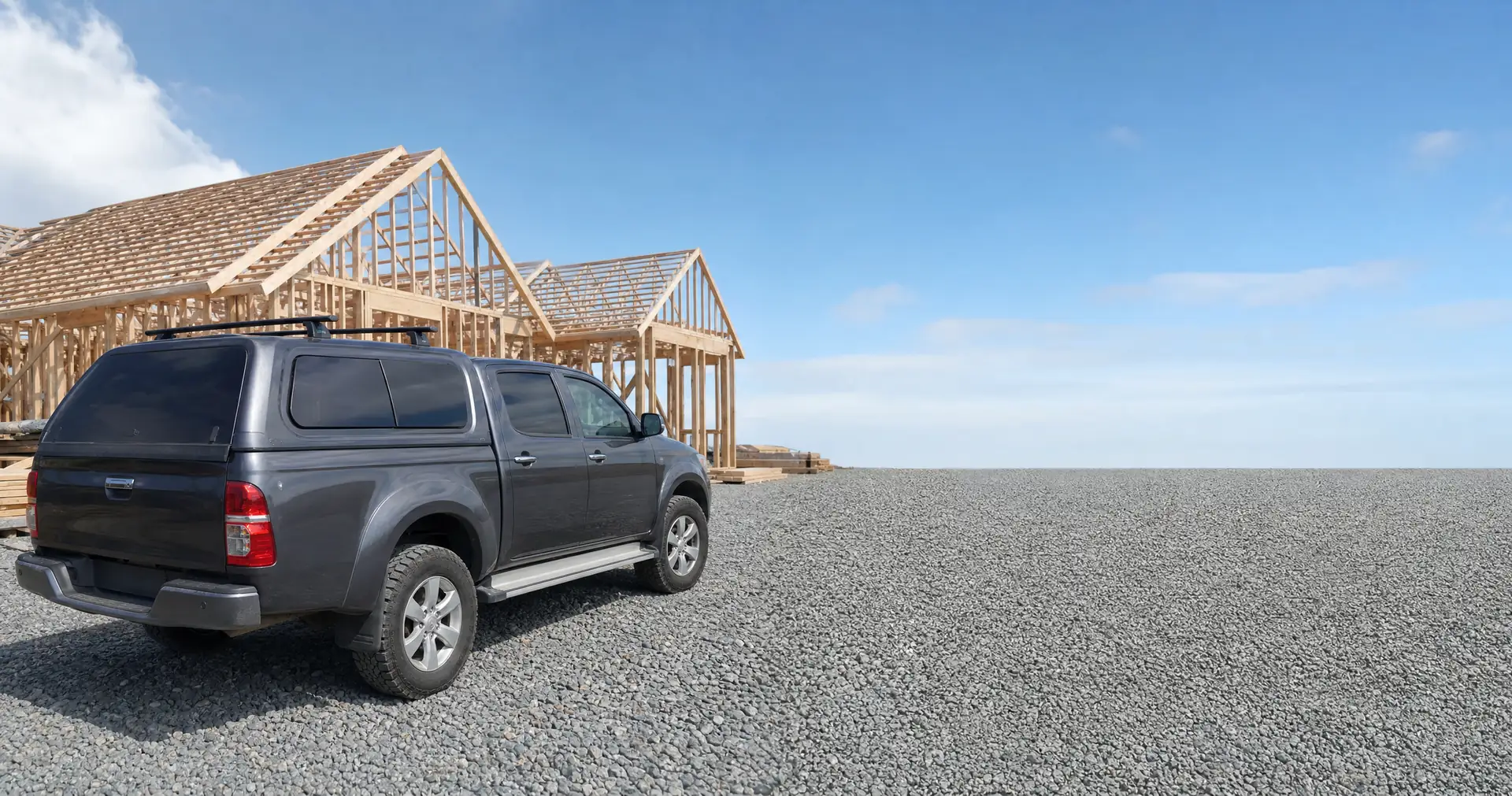 A flat-deck ute parked on gravel with its tray empty