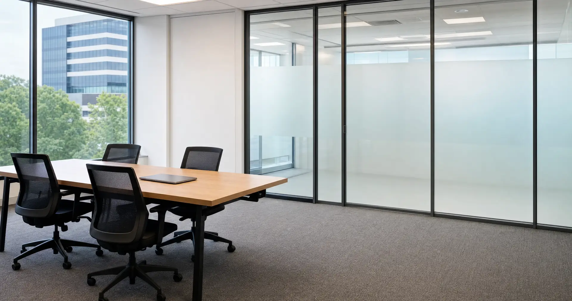 A meeting table with closed folders and a jug of water in an empty room